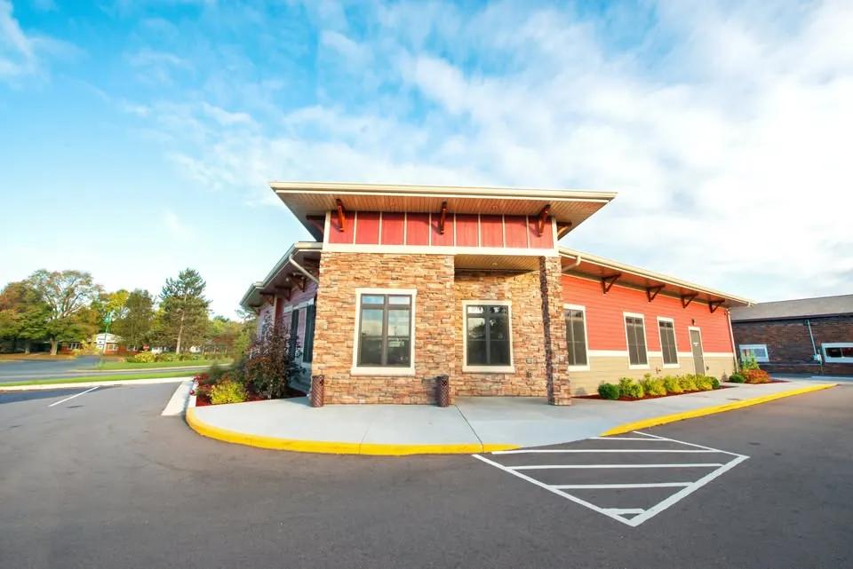 River Street Dental's office exterior in Spooner, WI — stone-and-red-cedar building with covered entry